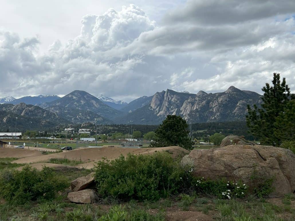 clemes and clemes estes park wool market 2023 rocky mountains in the background with greenery in the front